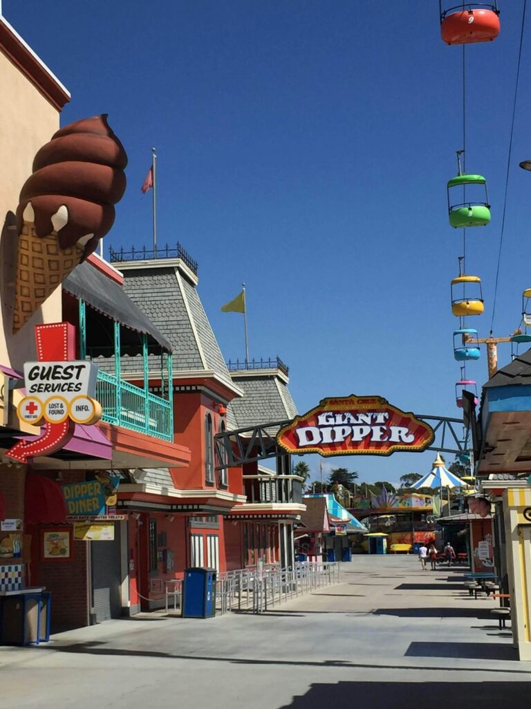 Sunny day at Santa Cruz Beach Boardwalk featuring the iconic Giant Dipper roller coaster.